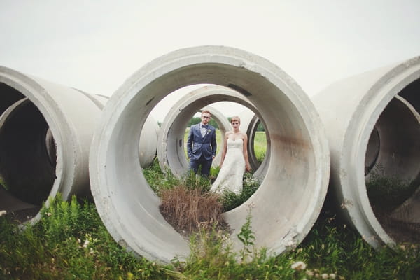 Bride and groom behind concrete cylinders - Picture by Josh Dookhie Photography