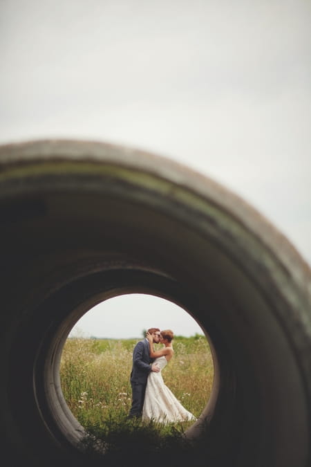 Picture of a bride and groom taken through a concrete cylinder - Picture by Josh Dookhie Photography