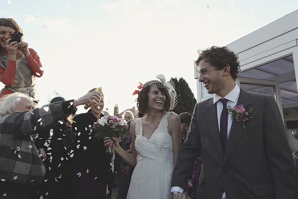Bride and groom walking shrough confetti shower - Picture by York Place Studios