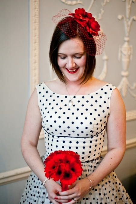 Bride with blue polka dot dress holding red bouquet - Picture by Anneli Marinovich Photography