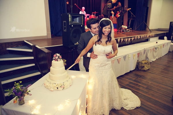 Bride and groom cutting cake - Picture by Mirrorbox Photography