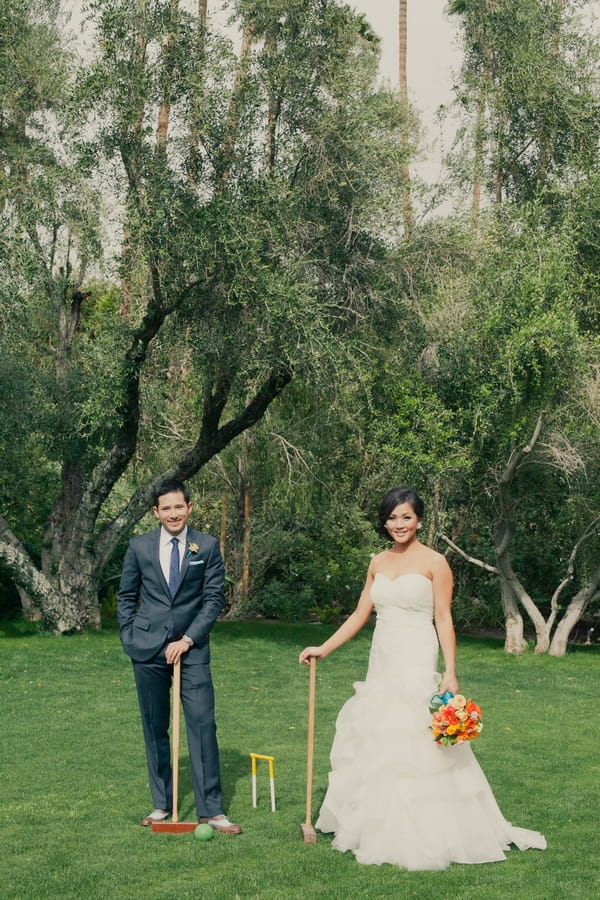 Bride and groom with croquet mallets - Picture by onelove photography