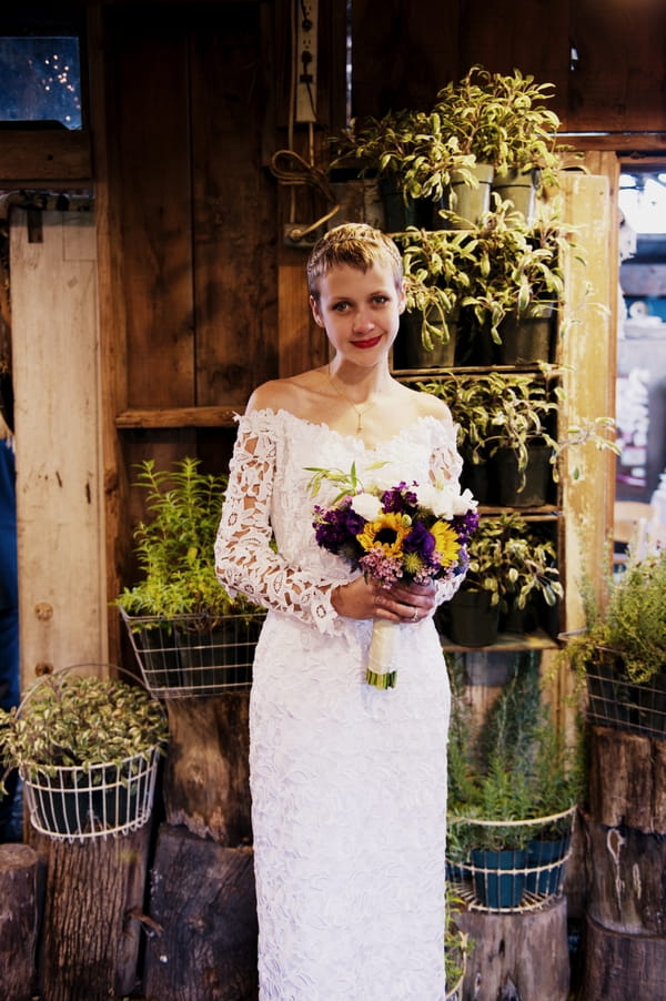 Bride in lace wedding dress holding bouquet - Picture by Judy Pak Photography