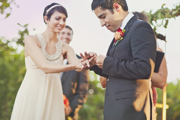 Groom placing ring on bride's finger - Picture by Our Labor of Love Photography
