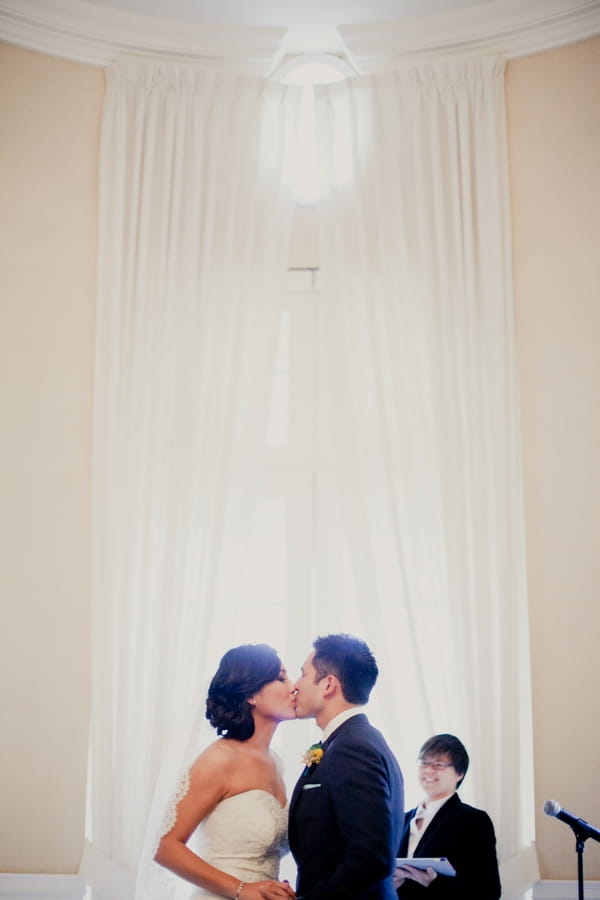Bride and groom kissing in wedding ceremony - Picture by onelove photography