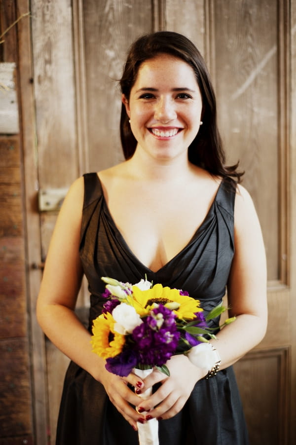 Bridesmaid in dark dress holding bouquet - Picture by Judy Pak Photography