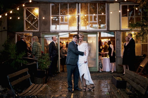 Bride and groom outside barn wedding venue in rain - Picture by Judy Pak Photography