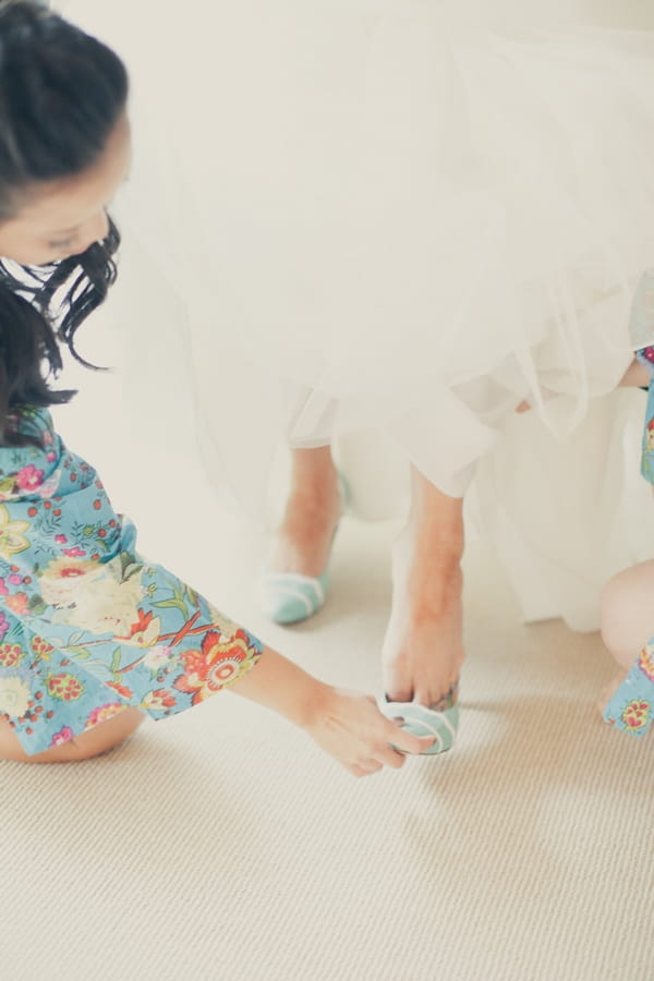 Bride putting on wedding shoes - Picture by onelove photography