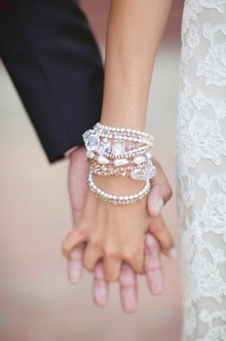 Close up of bride and groom holding hands - Picture by Joielala