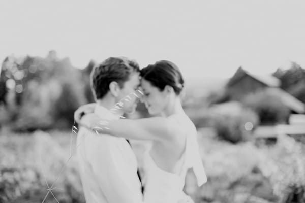 Black and white picture of bride and groom with arms around each other - Picture by Kate Harrison Photography