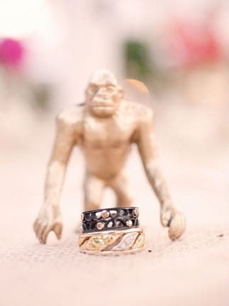 Small gold figure with wedding rings - Picture by Kate Harrison Photography