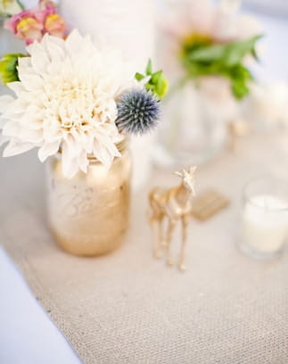 Small gold figure on wedding table as decoration - Picture by Kate Harrison Photography