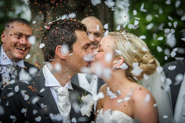 Bride and groom kissing during confetti shower - Picture by Pixies in the Cellar