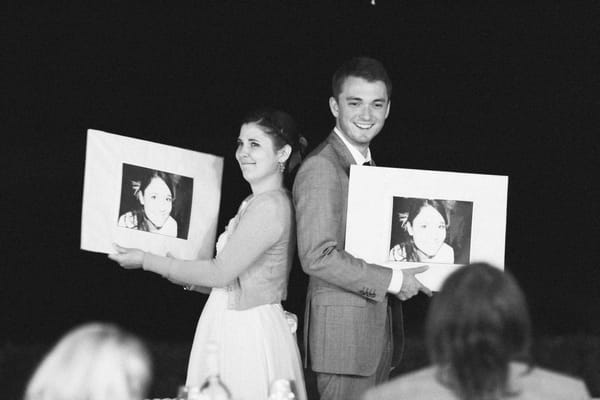 Bride and groom holding up pictures - Picture by DanielRM
