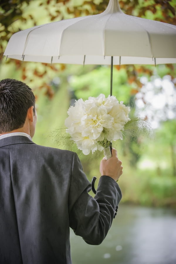 Groom holding umbrella - Picture by Pixies in the Cellar