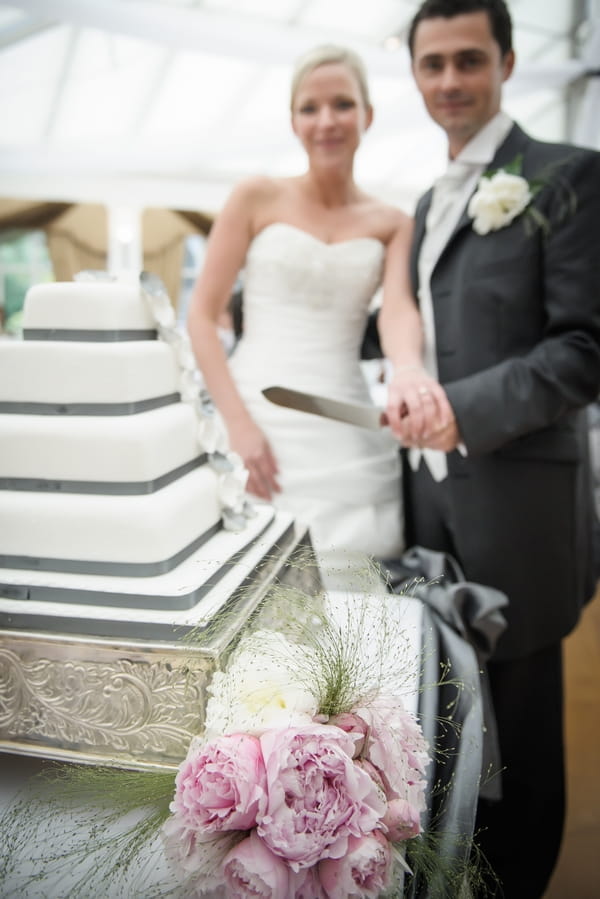 Bride and groom about to cut wedding cake - Picture by Pixies in the Cellar