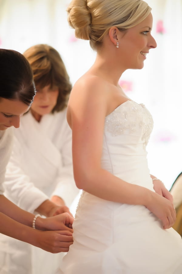 Bride having her wedding dress done up - Picture by Pixies in the Cellar