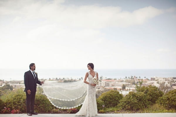 Groom holding brides veil - Picture by Joielala