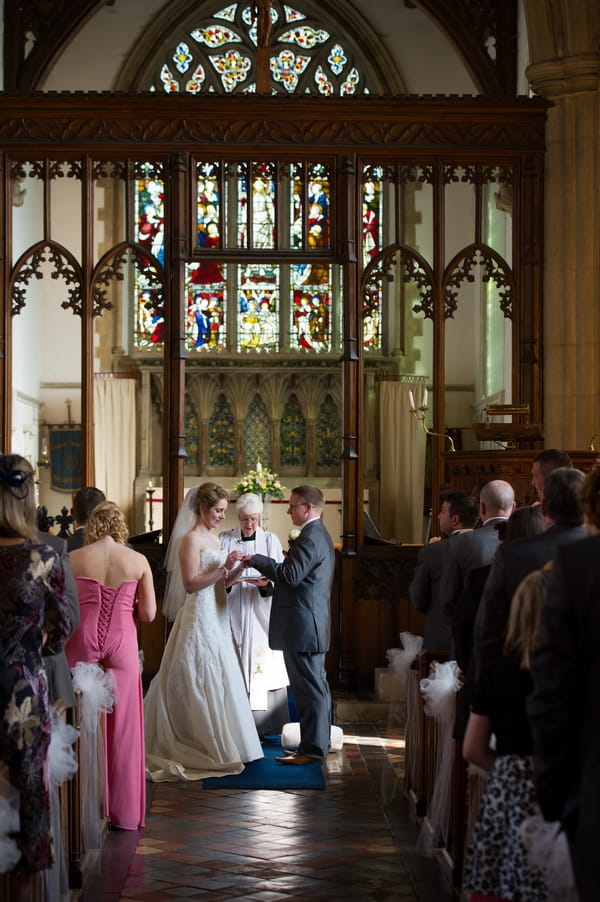 Bride and groom holding hands at altar - Picture by Gareth Squance Photography