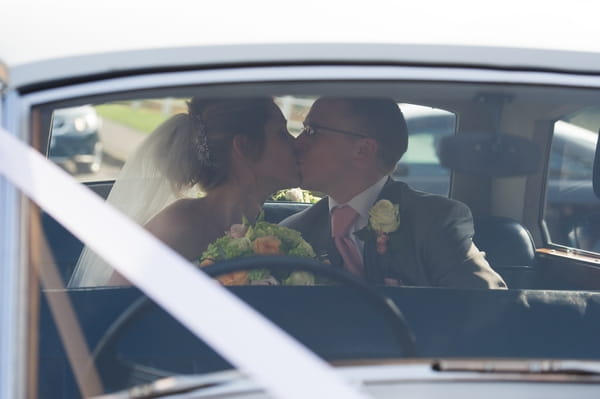 Bride and groom kiss in back of wedding car - Picture by Gareth Squance Photography