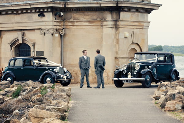Groom and best man standing by vintage wedding cars - A Homemade Marquee Wedding