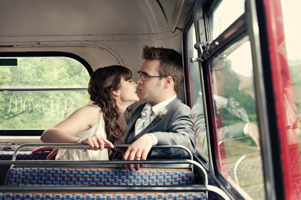 Bride and groom kiss in back of bus - A Homemade Marquee Wedding