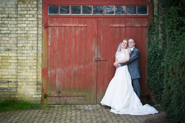 Bride and groom by red garage door - Picture by Gareth Squance Photography