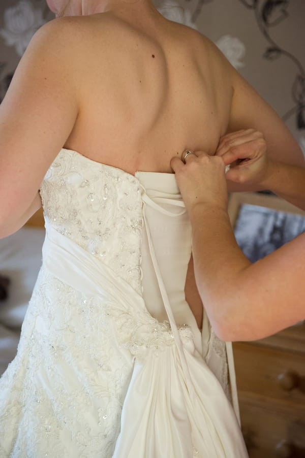 Back of wedding dress being fastened - Picture by Gareth Squance Photography