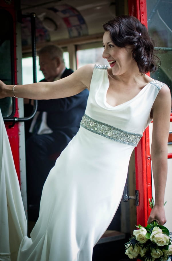 Bride hanging off back of red bus - Picture by Jonathan Bean Photography