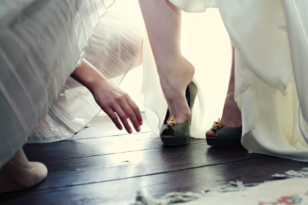 Bride putting on Alexander McQueen bridal shoes - A Homemade Marquee Wedding
