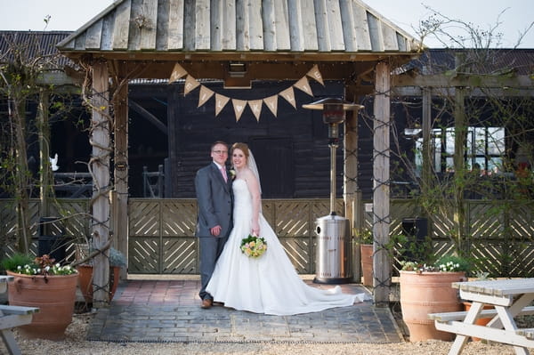 Bride and groom standing under bunting - Picture by Gareth Squance Photography