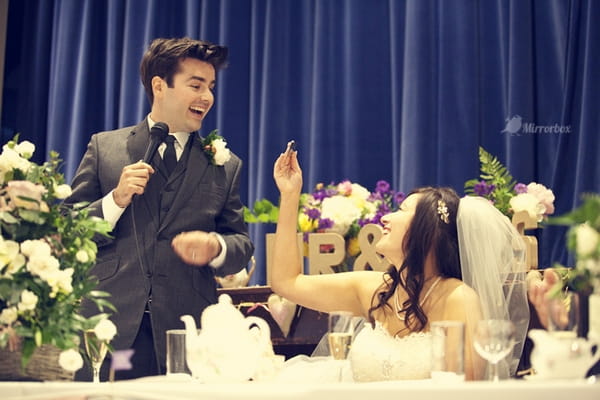 Groom smiling at bride during wedding speech - Picture by Mirrorbox Photography