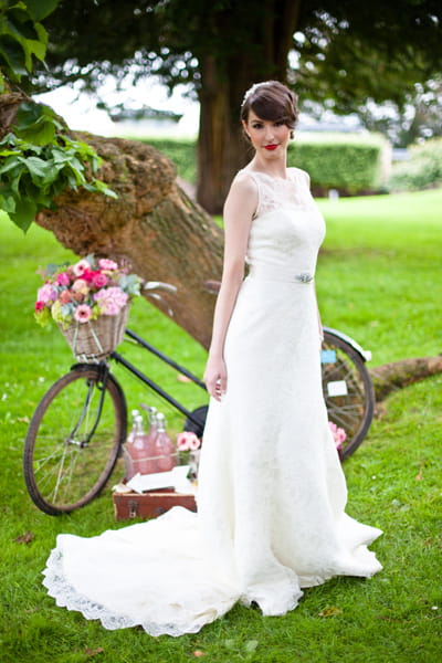 Model wearing wedding dress, standing in front of bicycle - LoveLuxe Launch