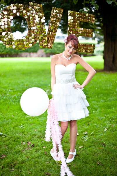 Model wearing wedding dress holding balloon - LoveLuxe Launch