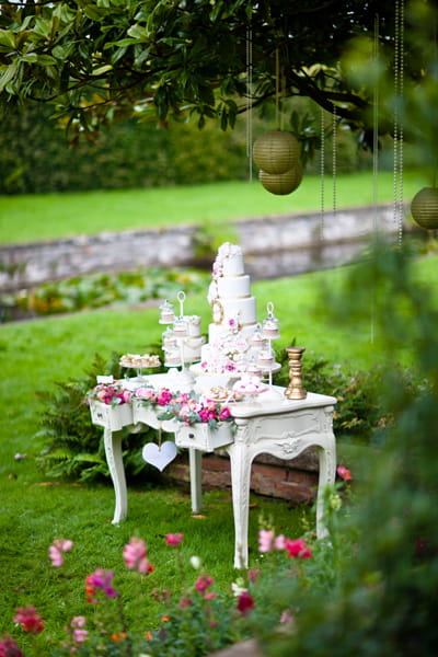 Tiered white wedding cake on white table - LoveLuxe Launch