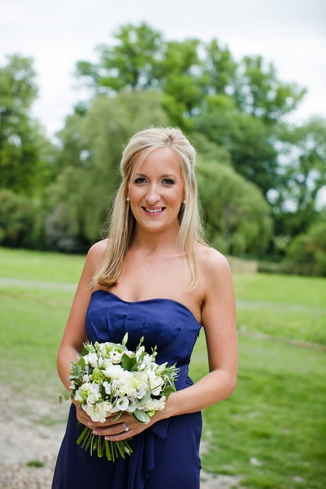 Bridesmaid in blue dress holding bouquet - A Beautiful Garden Party Wedding at Lains Barn