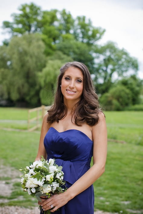 Bridesmaid in blue dress holding bouquet - A Beautiful Garden Party Wedding at Lains Barn