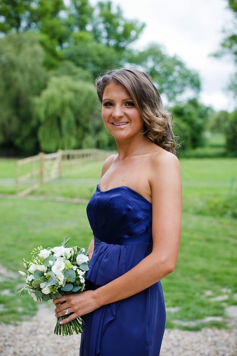 Bridesmaid in blue dress holding bouquet - A Beautiful Garden Party Wedding at Lains Barn