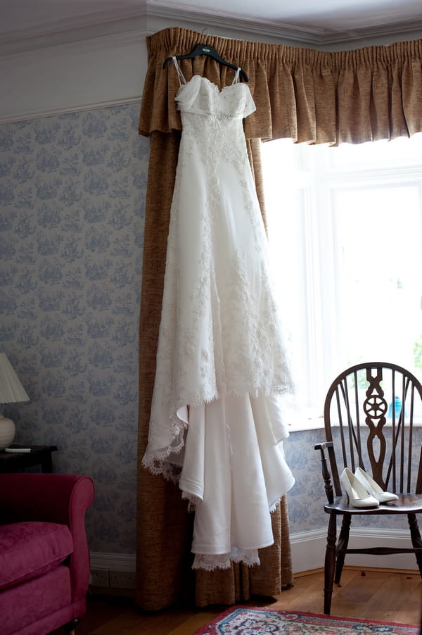 Wedding dress hanging over a curtain - A Wedstock Wedding in Hertfordshire