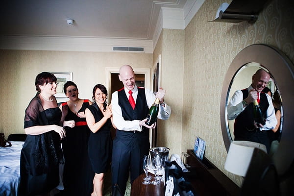 Groom opening bottle of Champagne - An Art Deco Themed Civil Partnership