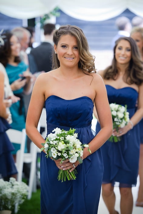 Bridesmaid in blue dress walking up the aisle - A Beautiful Garden Party Wedding at Lains Barn