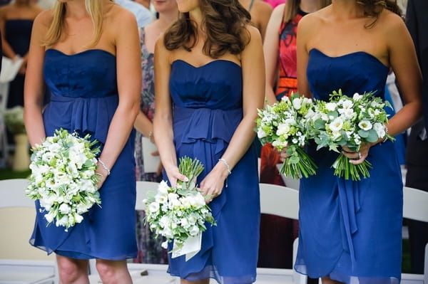 Bridesmaids in blue dresses holding bouquets - A Beautiful Garden Party Wedding at Lains Barn