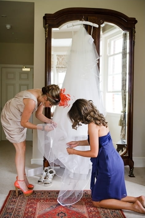 Bridesmaid adjusting wedding dress - A Beautiful Garden Party Wedding at Lains Barn