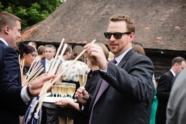 Guest taking confetti wand - A Beautiful Garden Party Wedding at Lains Barn