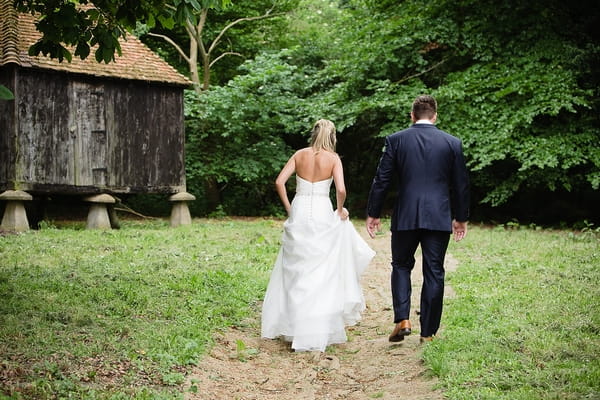 Bride and groom walking to have pictures taken - A Beautiful Garden Party Wedding at Lains Barn