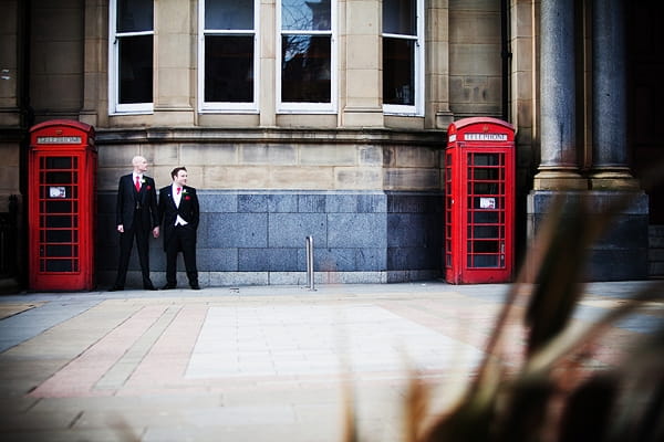 Civil partners standing between 2 red telephone boxes - An Art Deco Themed Civil Partnership