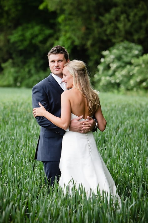 Groom holding bride in field - A Beautiful Garden Party Wedding at Lains Barn