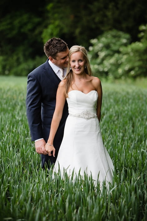 Bride and groom holding hands in field - A Beautiful Garden Party Wedding at Lains Barn