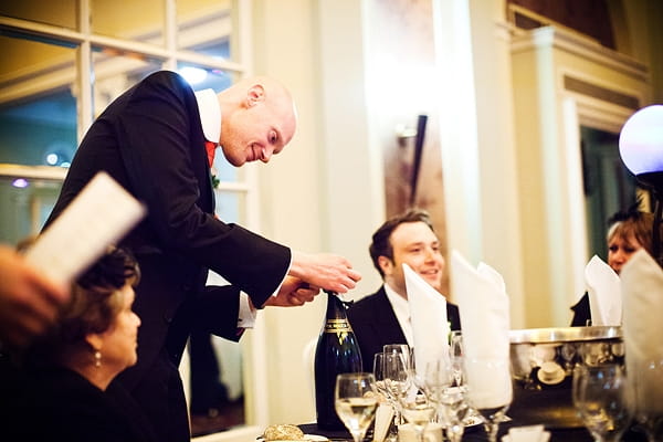 Groom opening a bottle of Champagne - An Art Deco Themed Civil Partnership