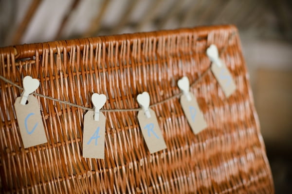 Cards sign made from luggage tags, hanging on basket - A Beautiful Garden Party Wedding at Lains Barn